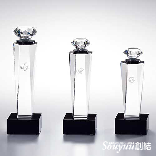ダイヤモンドモチーフ光学ガラス製表彰楯 CKS-145 楕円形の本体のトップにダイヤモンドのモチーフをつけて香水瓶のようなイメージしています。女性用の表彰には最適な商品です。Aサイズ高さ210mm重さ1260g 28000円、Bサイズは高さ185mm重さ880g 25000円、Cサイズは高さ160mm重さ590g 23000円です。